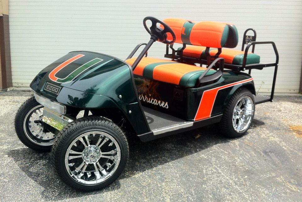 Golf cart upholstery with custom upholstery in University of Miami colors, featuring vibrant orange and green leather seats with white accents, crafted by Chair Care Upholstery in Hollywood, FL