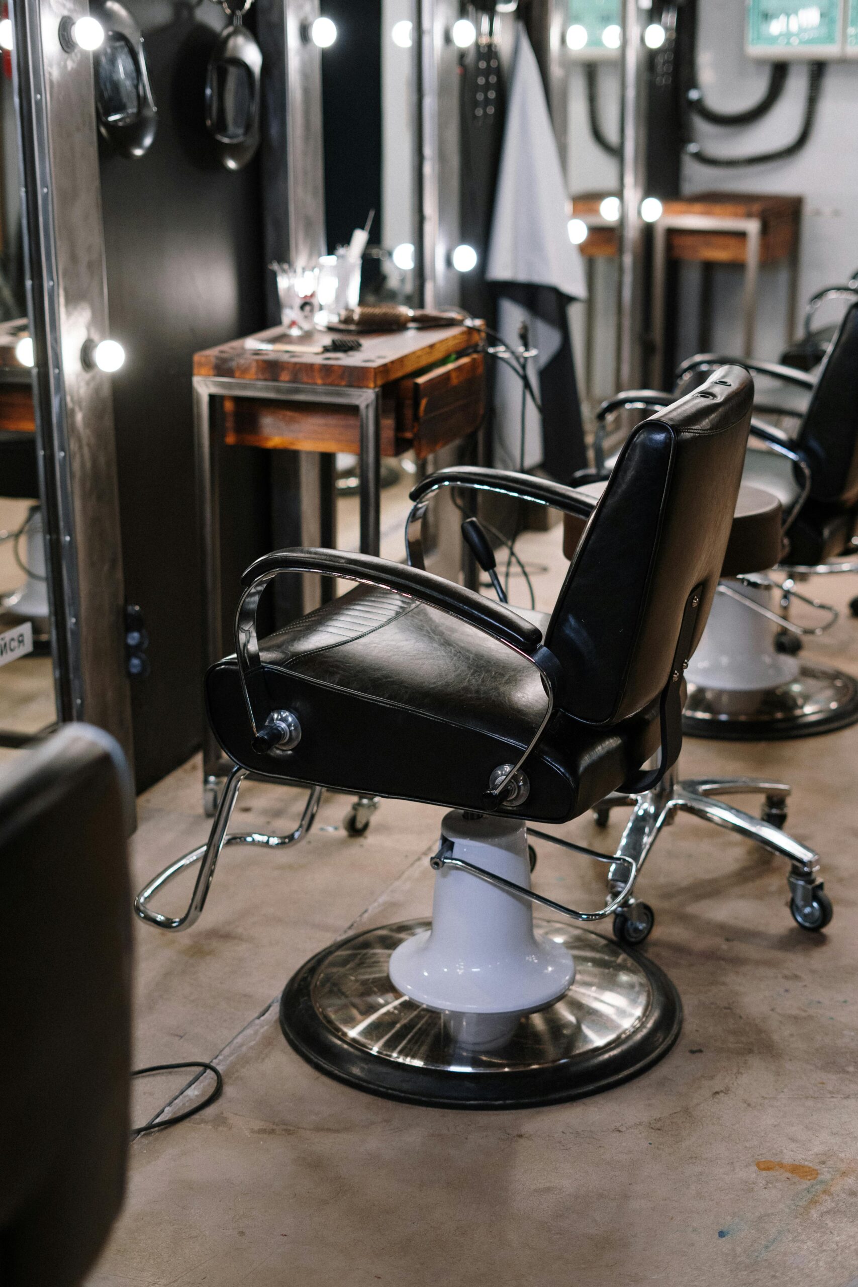 Professional barbershop upholstery services by Chair Care Upholstery in Hollywood, FL Empty barber shop with sleek chairs and illuminated mirrors.