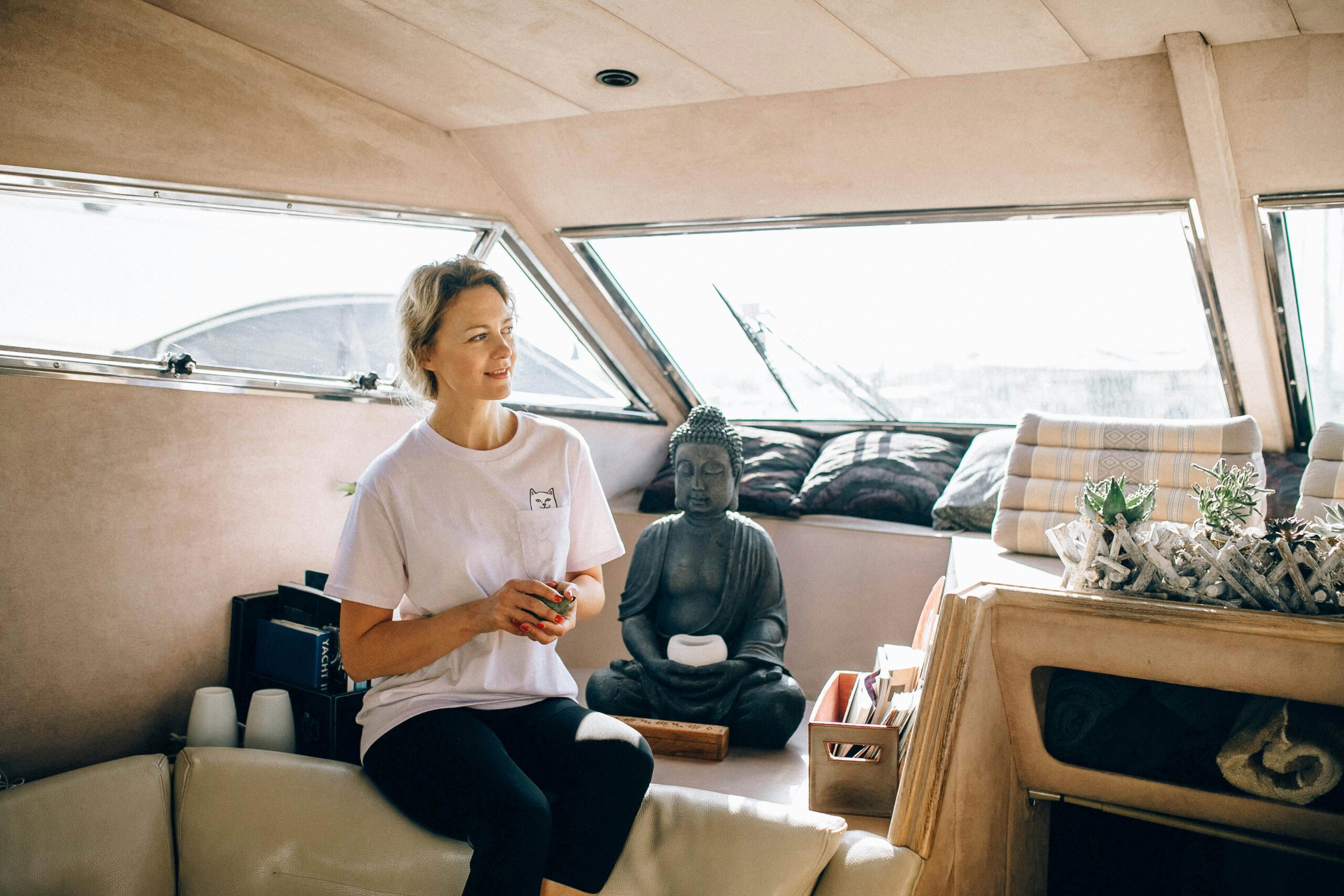 Woman enjoying relaxation on a yacht with a serene Buddha statue.